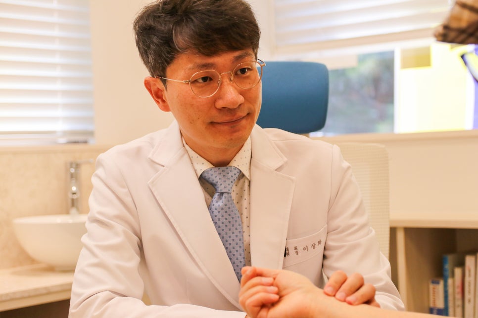 진료실에서 환자의 맥을 짚으며 상담하는 이상화 대표원장